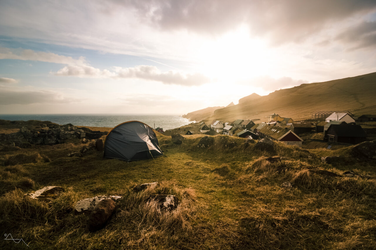 tent in front of mykines village and sunset